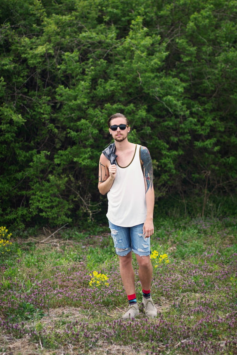 The Kentucky Gent for CAT Footwear's Summer Festival Style campaign in BDG Tank, Devil's Harvest Plaid, Levi's Denim Shorts, Richer Poorer Socks, and Caterpillar Suede Chukka Boots